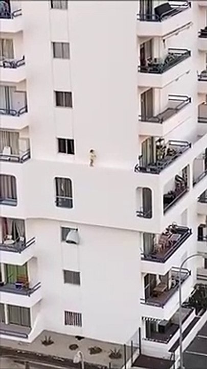 Une fillette marche sur le rebord de l'immeuble au 4ème étage... Terrifiant