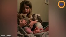 Ce chiot dort dans les bras d’une fillette, bercée par le chant de la petite fille