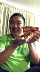 Regardez comment il mange une portion de pizza en une seule bouchée.