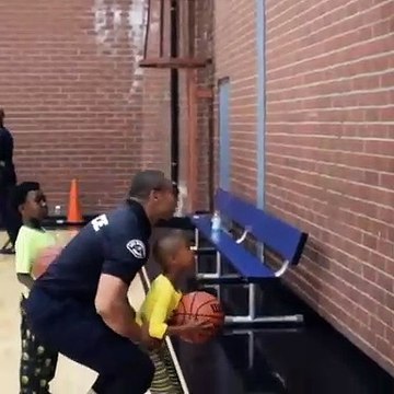 Dunk d'un enfant.. porté par un policier au panier de basket !