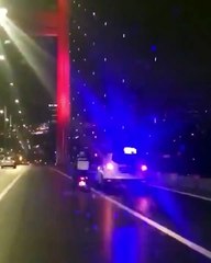 İstanbulda motorlu bir arkadasın köprüden geçerken şiddetli fırtınadan etkilenmemesi için yardımcı olan polis ekibi