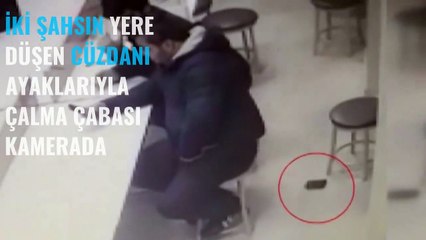 İki şahsın yere düşen cüzdanı ayaklarıyla çalma çabası kamerada