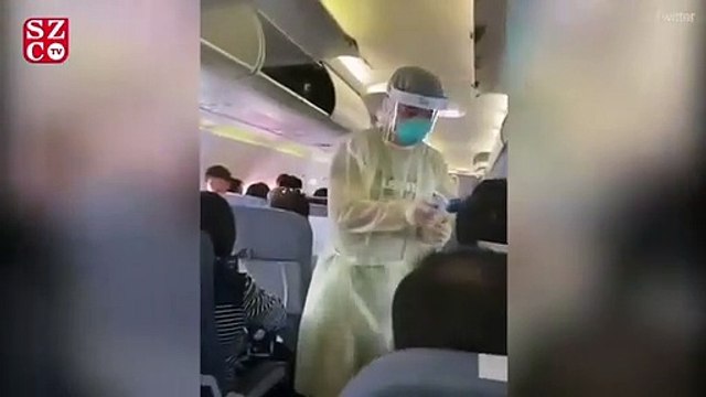 Çinli sağlık görevlileri uçakta ateş ölçümü yaptı