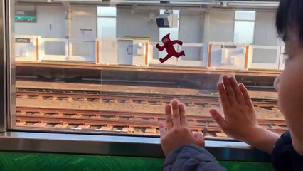 Download Video: Mignon : Un enfant s'amuse en utilisant avec une feuille transparente et la vitre d'un train