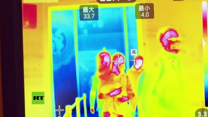 Los médicos toman la temperatura corporal de los pasajeros en un aeropuerto de Tianjin en China por el mortal coronavirus