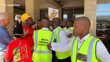 Environmental activists dump buckets of coal outside conference venue in Cape Town
