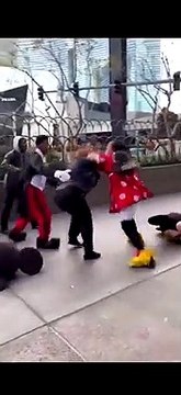 Une femme habillée en Minnie en pleine bagarre avec une agent de sécurité avant que deux hommes en Mickey et en Dingo ne les séparent