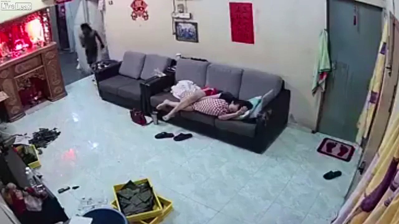 Ce cambrioleur se balade autour de la propriétaire qui dort sur le canapé !