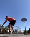 Guy Dribbles Two Basketballs and Throws Them in Basket While Balancing Himself Over Slackline
