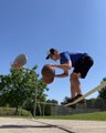Guy Balances Himself Over Slackline While Throwing Two Basketballs in Basket After Dribbling Them
