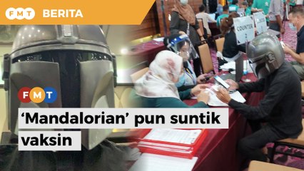 Lelaki pakai topi Mandalorian semasa suntik vaksin Covid-19
