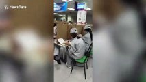 Chinese workers separated by cardboard as they eat to avoid spread of coronavirus