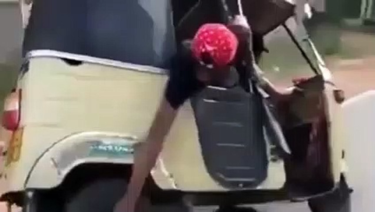 Il change la roue de son tuk-tuk sans s'arrêter