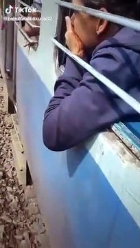 Un homme suspendu au compartiment d'un train et perd l'équilibre et dégringole sur les voies ferrées