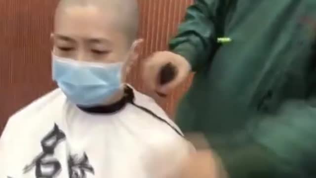 Espectaculares imágenes de enfermeros chinos rapándose el pelo