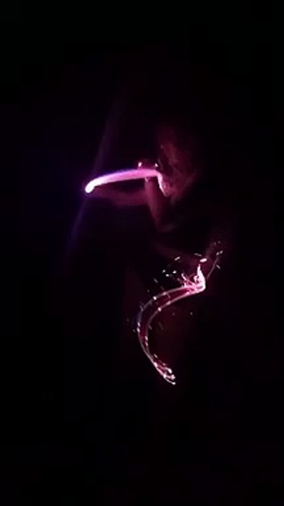 Une fille danse avec un fils LED lumineux dans le noir et c'est super cool !