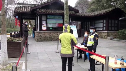 Tourists wearing masks visit China's West Lake on its first day of reopening