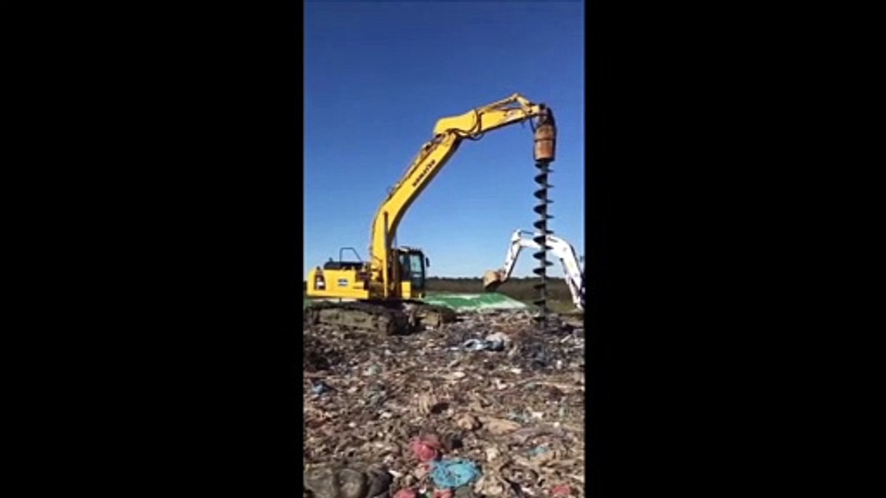 Pelle sur chenilles KOMATSU PC 290 équipée d'une tarière pour un centre d'enfouissement