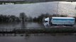 Vehicles plough through streets submerged by floodwater in northern UK