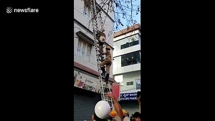 Botched burglar gets stuck on third floor ledge in India and has to be saved by firemen