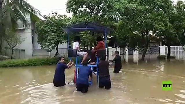 شاهد.. الإندونيسيين يحولون الفيضانات إلى حمام سباحة