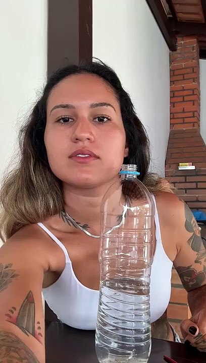 Woman Practices Magic Trick with an Apple and a Bottle