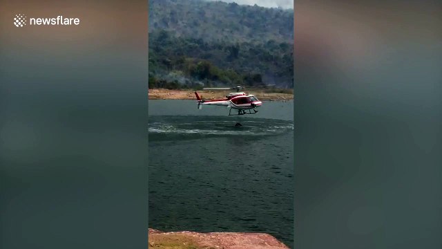 Helicopters dump water on forest fires in Thailand
