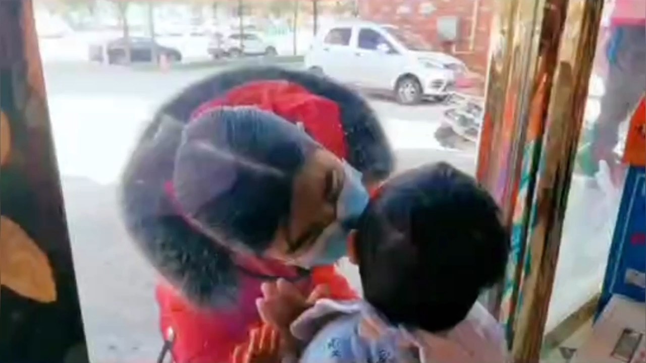 Chinese nurse kisses son through glass window a...