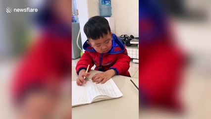 Toddler nods off while practising writing Arabic numerals