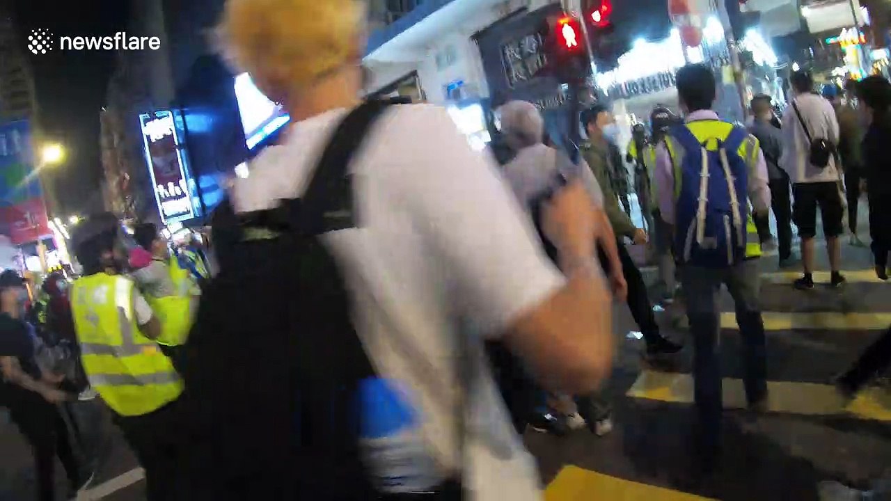 Tense moment isolated Hong Kong police officer points gun as he is surrounded by protesters
