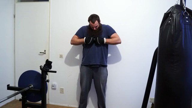 Old time strongman JK bending two 0.6 x 18 cm nails into a shape