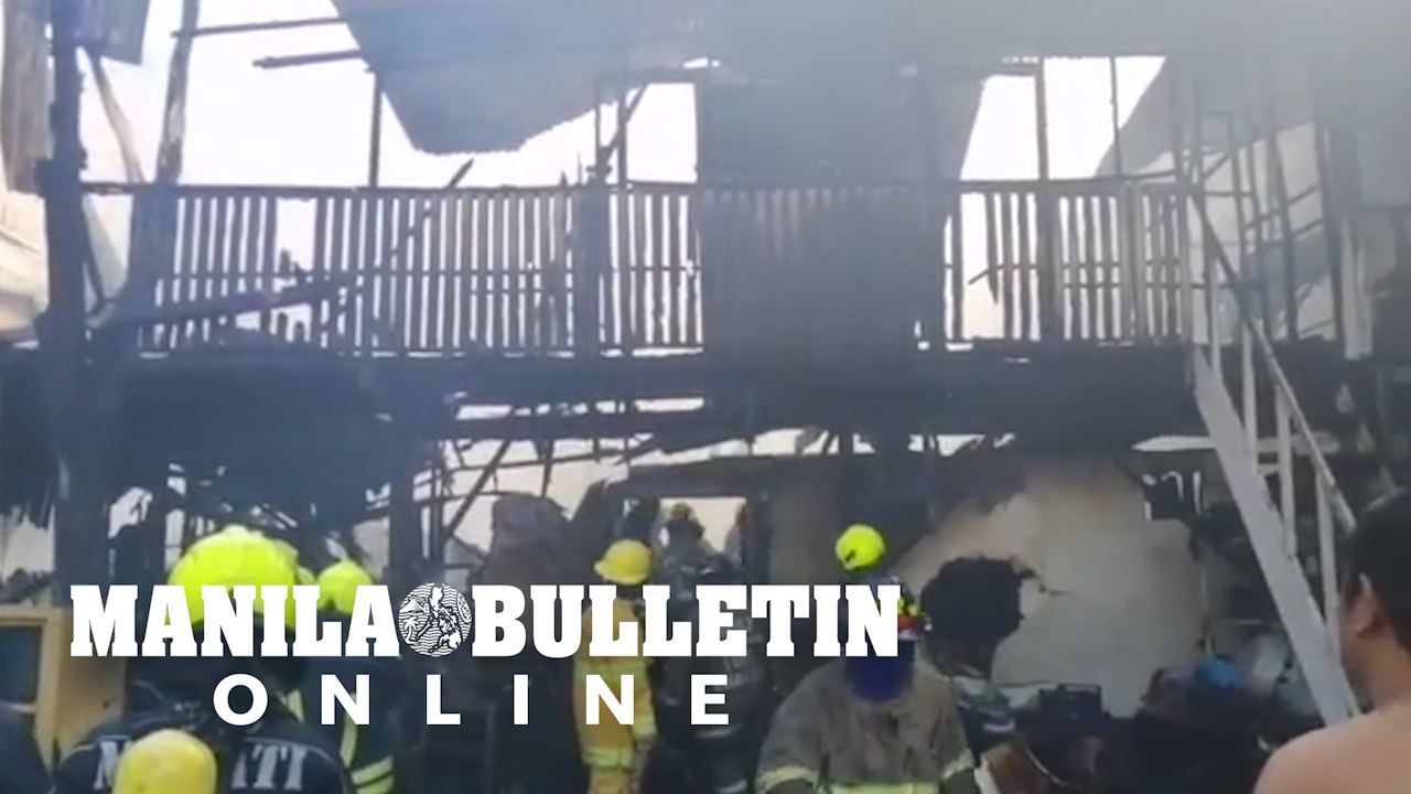Firefighters extinguish an on going fire inside a warehouse at Zobel, Makati