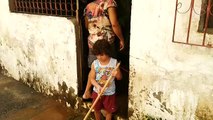 Neto de cinco anos ajuda avós a limpar casa tomada  por água
