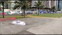 Morador de rua dorme enrolado em saco plástico para se proteger da chuva