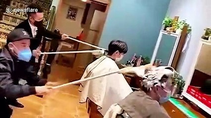Hairdressers in China attach tools to sticks to keep safe distance from customers amid COVID-19 outbreak
