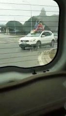 Un joven pasea por Cádiz subido a su tobogán de plástico atado a un coche