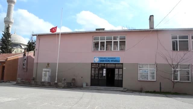 İki öğrenci yarıya indirilmiş Türk bayrağını selamlayıp göndere çekti