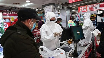 Dans un supermarché de Pékin, les employés portent des combinaisons contre le Covid-19