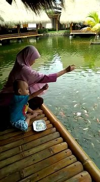 Mother n son helping fishes in water