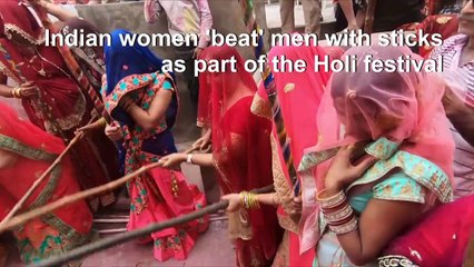 Stick em' up! Indian women 'beat' men during Holi festival