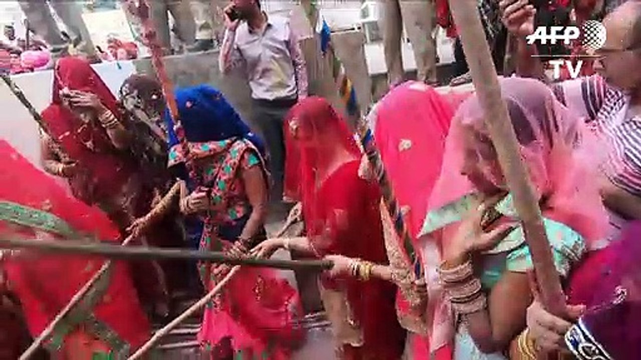 Männer kriegen Schläge beim 'Lathmar Holi'-Fest