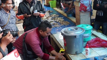 Health volunteers provide advice on how to slow spread of Coronavirus at market in Indonesia