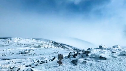 Incredible cloud formation races over snowy mountain top