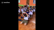 Thai schoolchildren take part in hilarious game passing plates full of flour over their heads