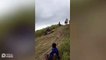 Teenagers Slide Down Grassy Hill