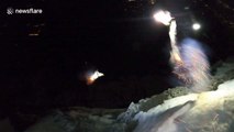 French adrenaline junkies wingsuit from mountain with fireworks attached to their feet