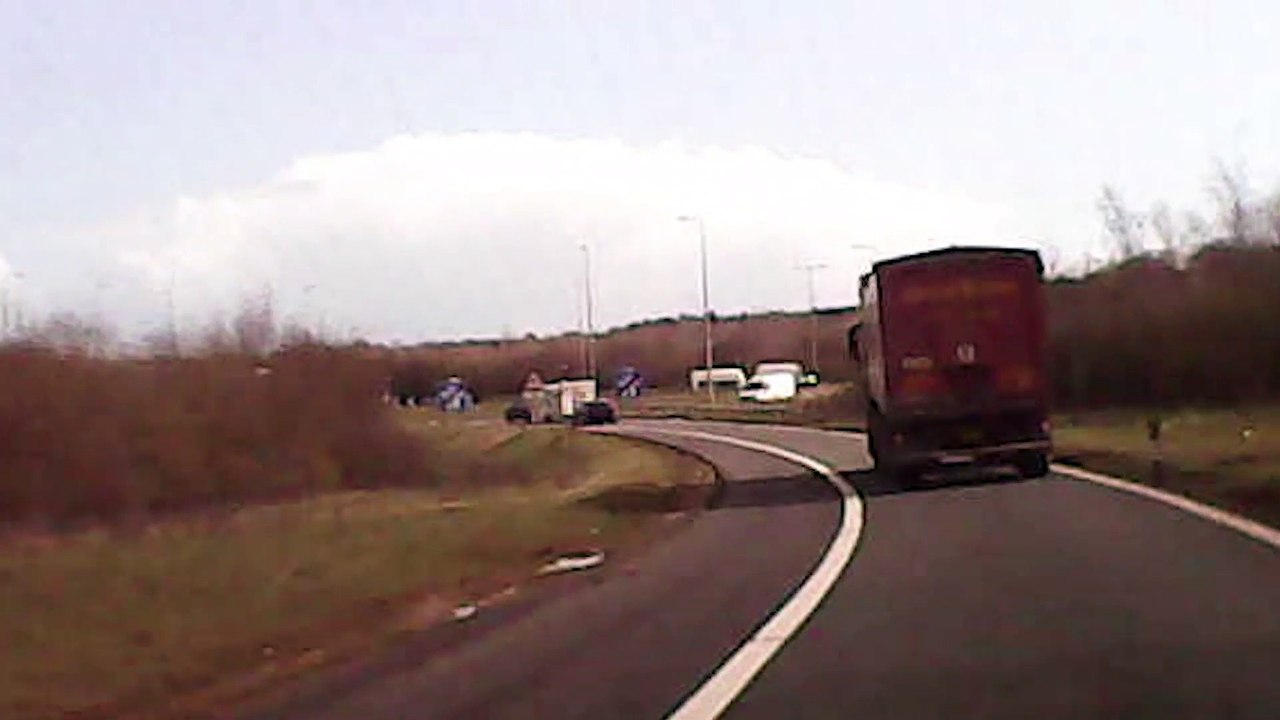 Race car falls out the back of a trailer