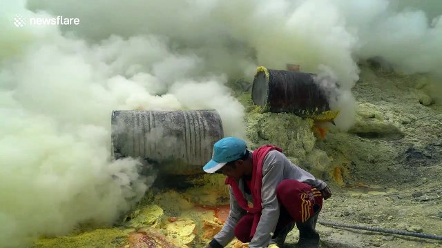 Indonesian miners work in clouds of poisonous gas as they mine sulphur from volcano crater