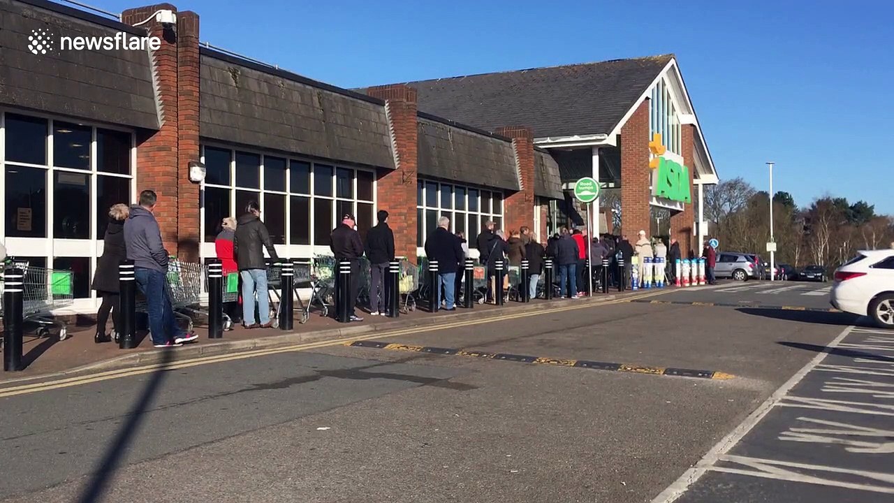 UK shoppers queue around Asda car park despite pleas not to "panic buy"