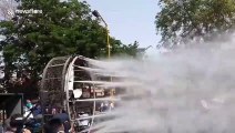 Indian officials use high-pressure water jets attached to fan to spray disinfectant